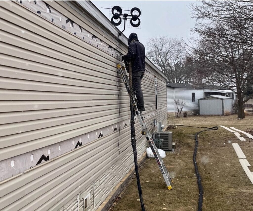 Cozy Walls technician injecting foam wall insulation from outside a Wisconsin home